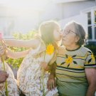 Older couple being greeted by two children with kisses on the cheek